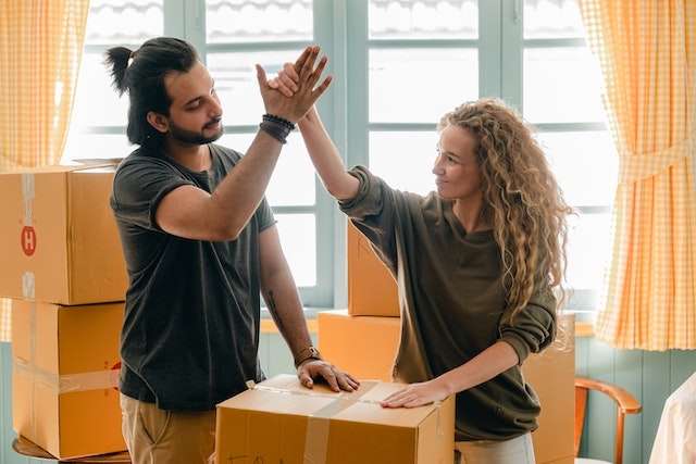 Couple high-fiving to each other while packing for their move
