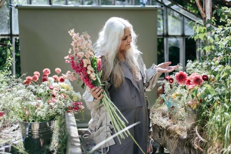 Woman with gray hair holding flowers.